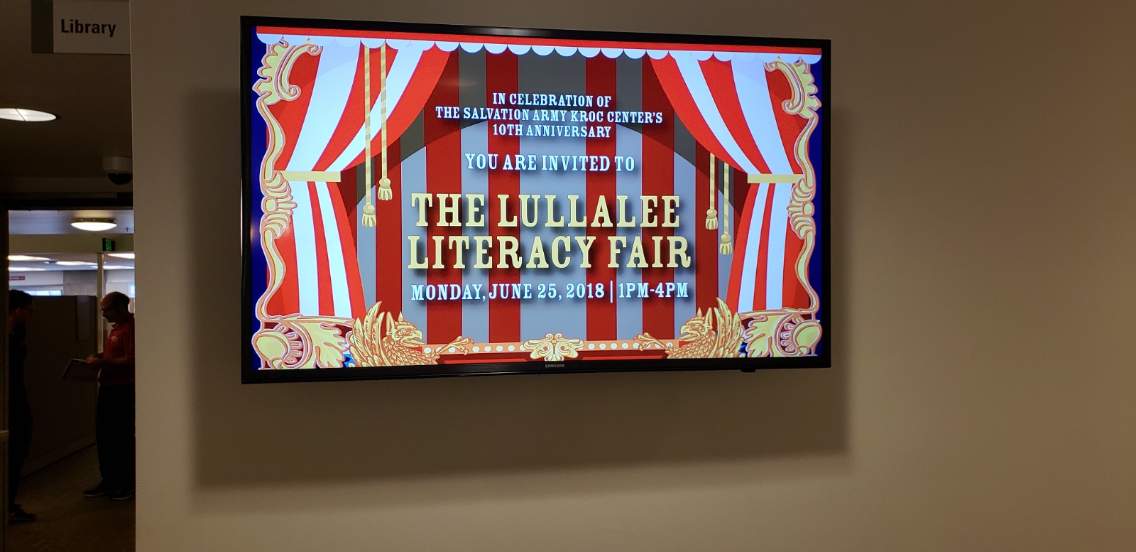 A large screen tv with the words " the lullae literacy fair ".