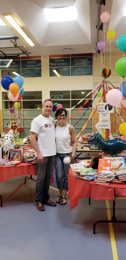 A man and woman standing in front of some books