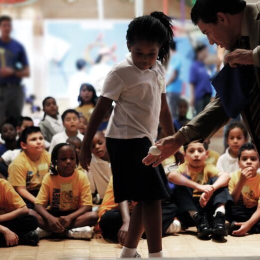 A group of children and adults in front of a crowd.